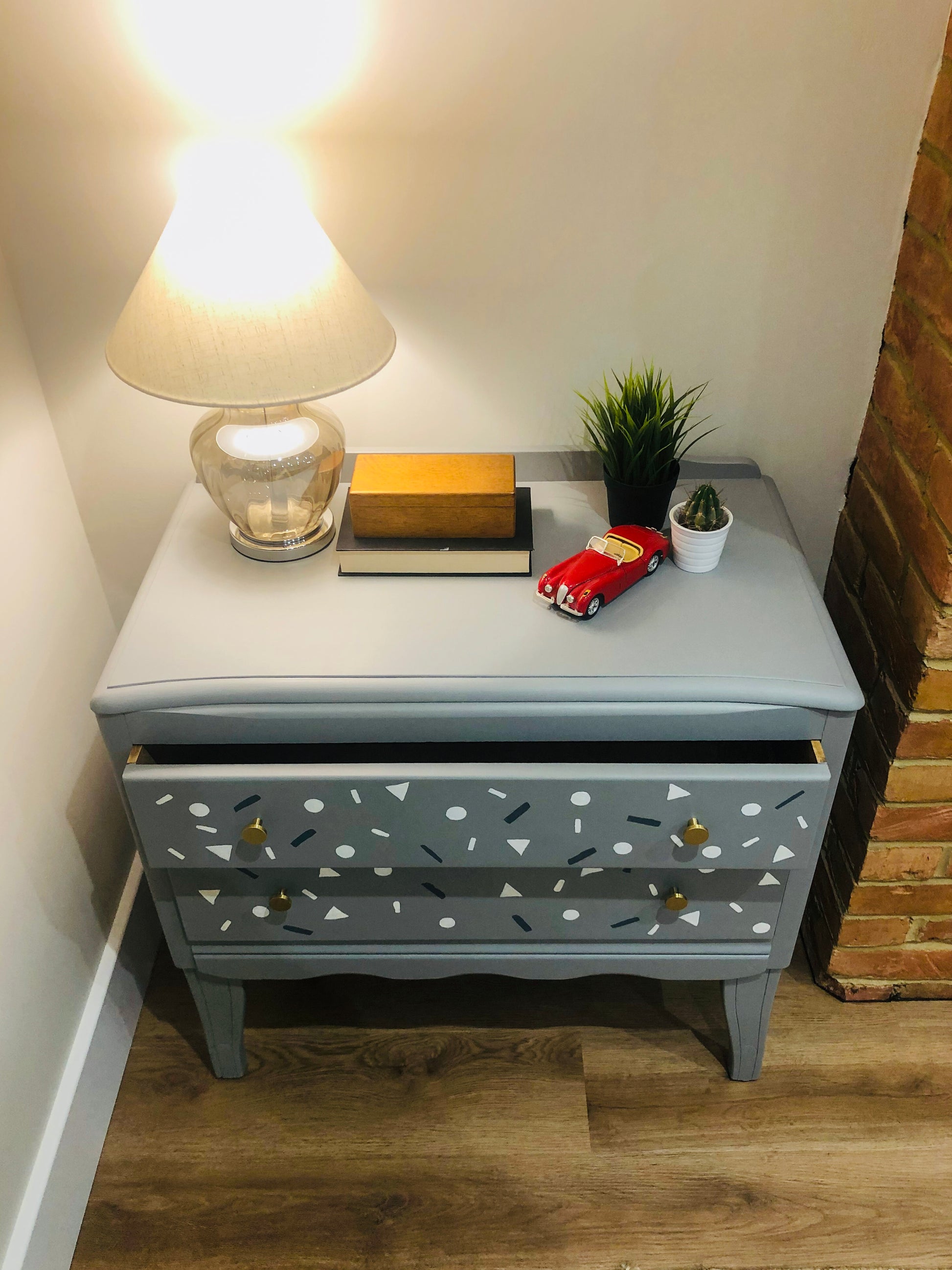 Small Harris Lebus chest of drawers in grey with small shapes painted on the drawers
