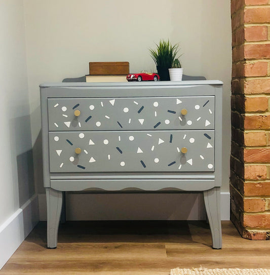 Small Harris Lebus chest of drawers in grey with small shapes painted on the drawers