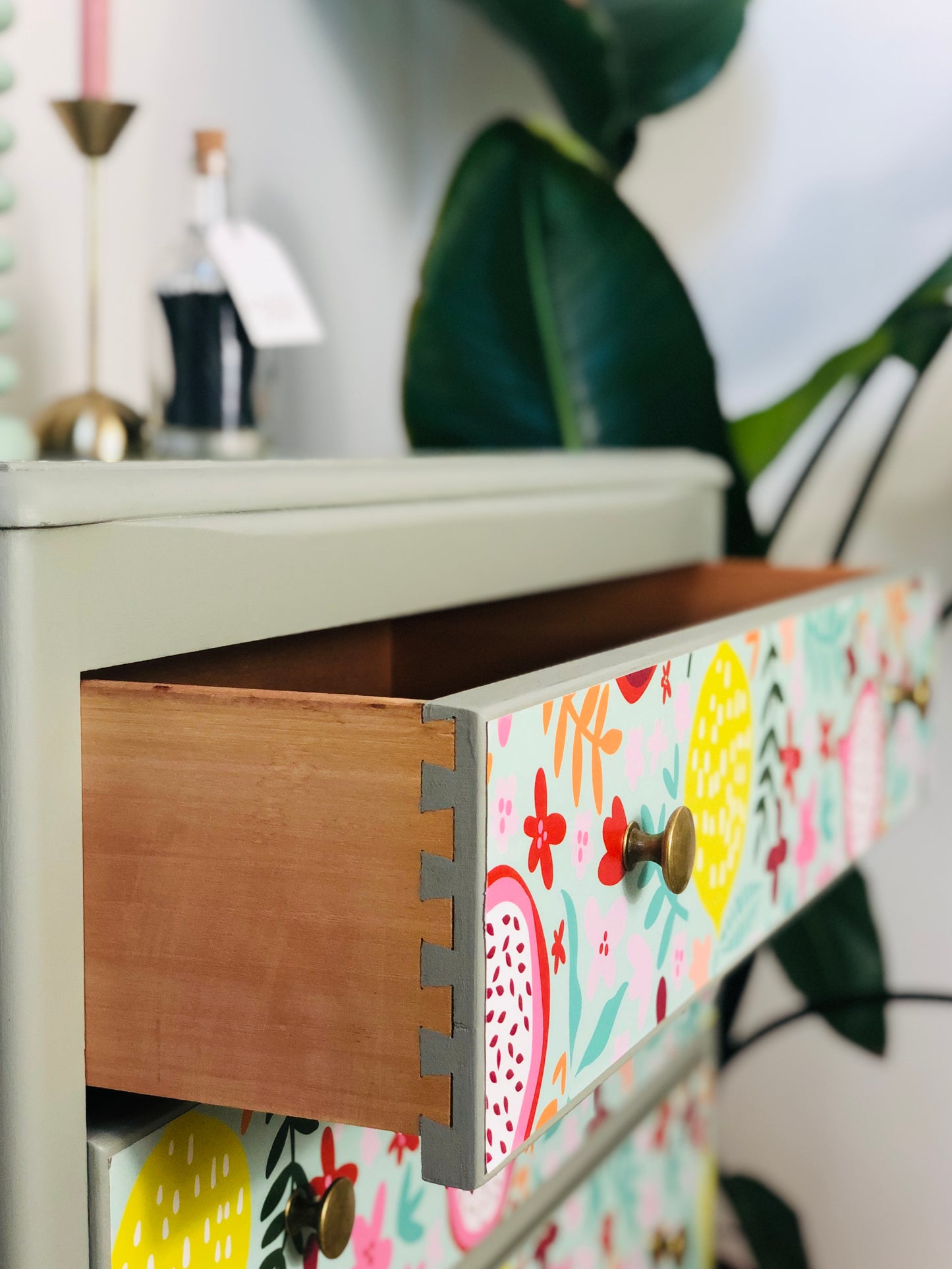 . Chest of Drawers, Painted Neutral Green, With Colourful Fruit And Floral Wallpaper Design