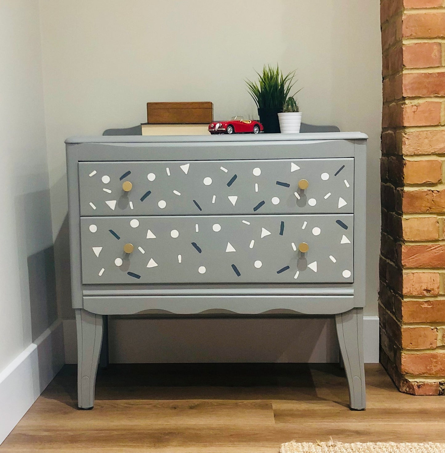 Small Harris Lebus chest of drawers in grey with small shapes painted on the drawers