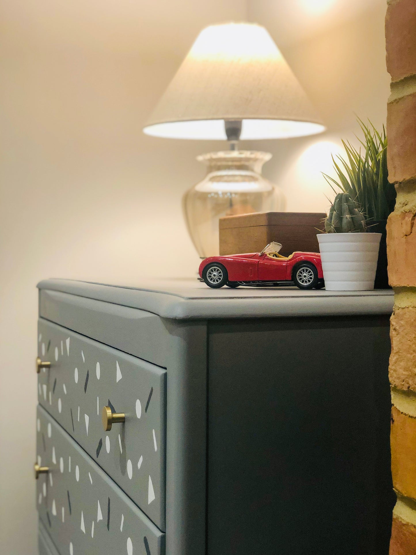 Small Harris Lebus chest of drawers in grey with small shapes painted on the drawers