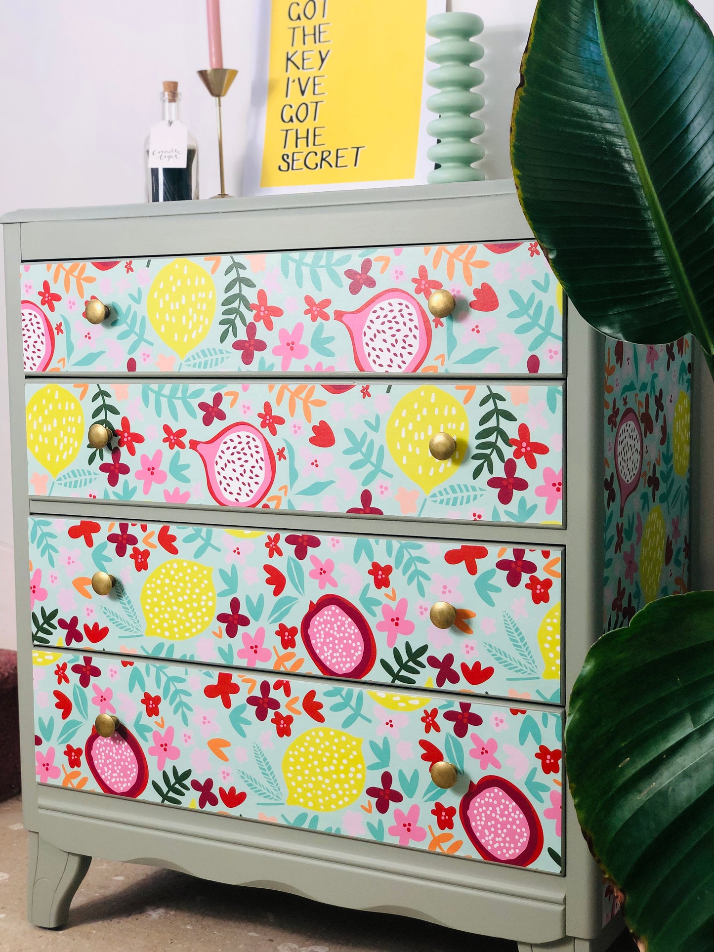 . Chest of Drawers, Painted Neutral Green, With Colourful Fruit And Floral Wallpaper Design