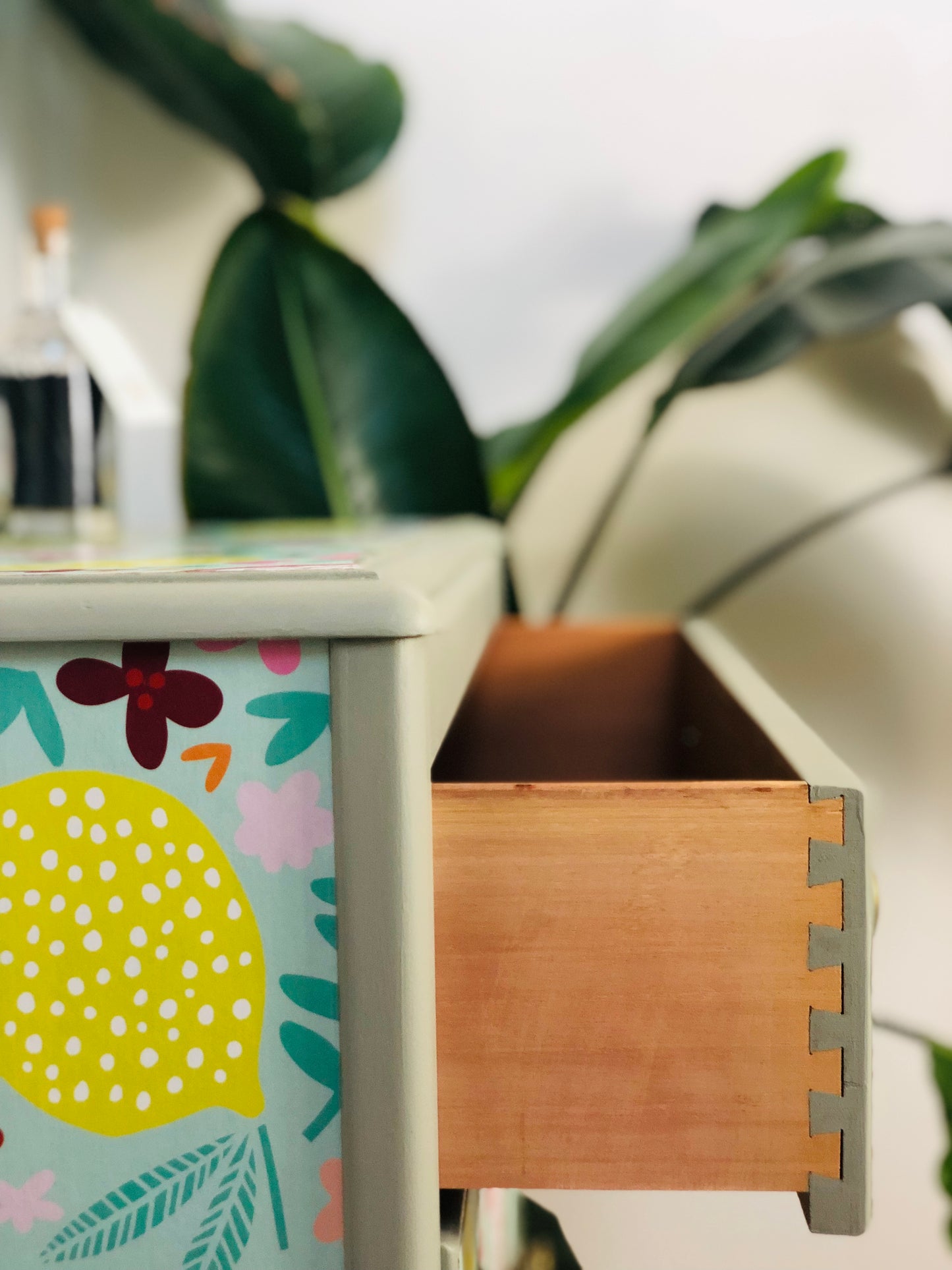 . Chest of Drawers, Painted Neutral Green, With Colourful Fruit And Floral Wallpaper Design