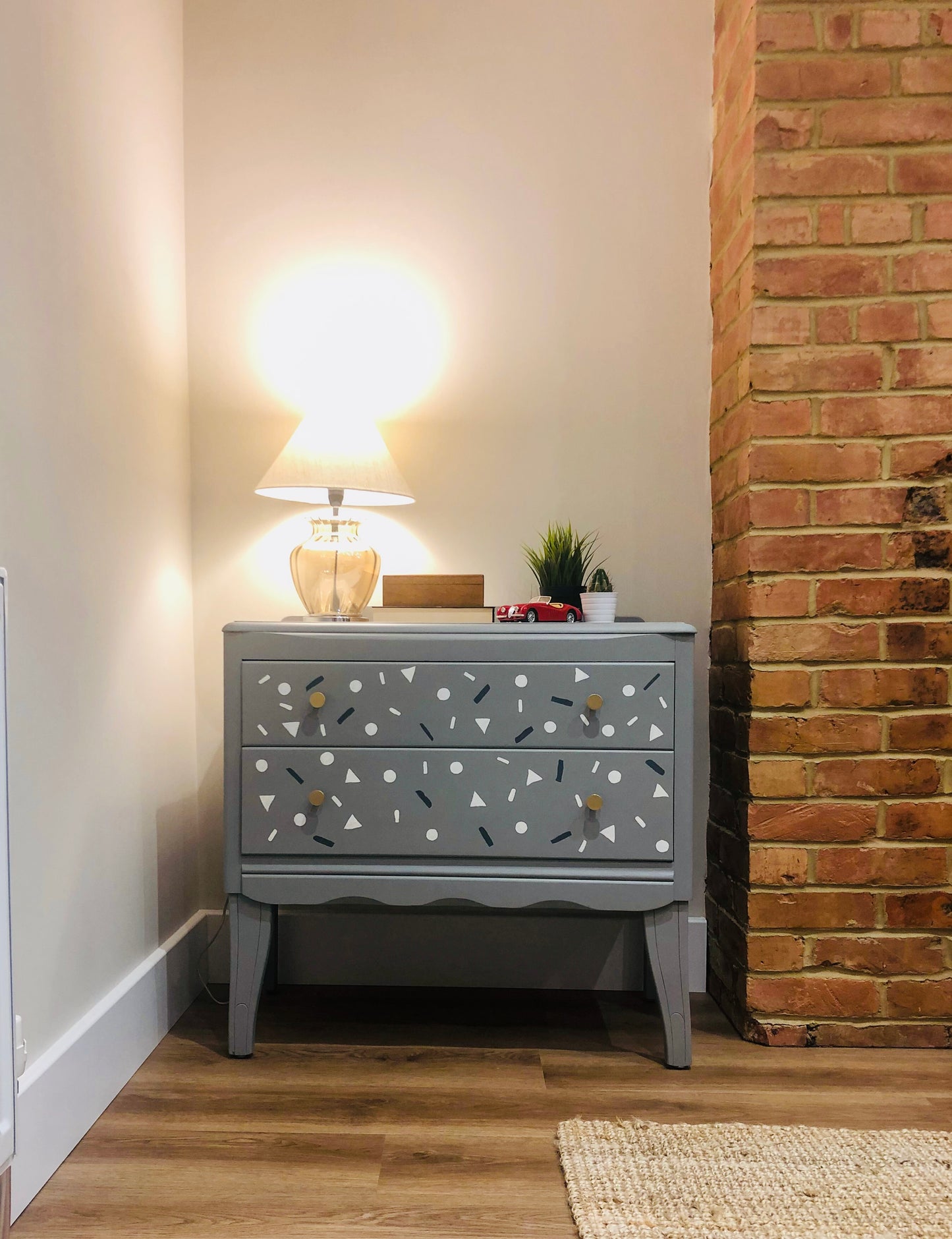 Small Harris Lebus chest of drawers in grey with small shapes painted on the drawers