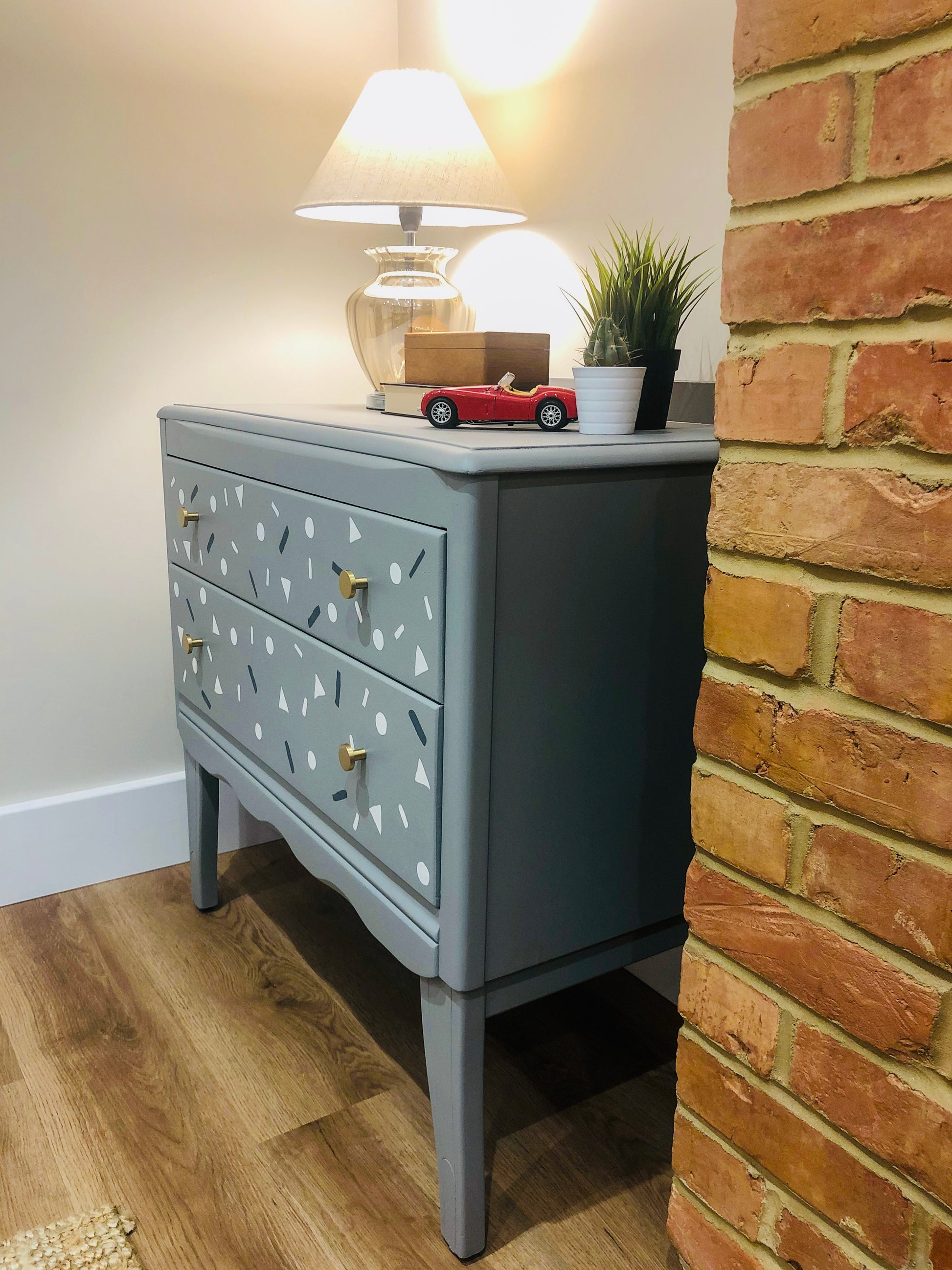 Small Harris Lebus chest of drawers in grey with small shapes painted on the drawers