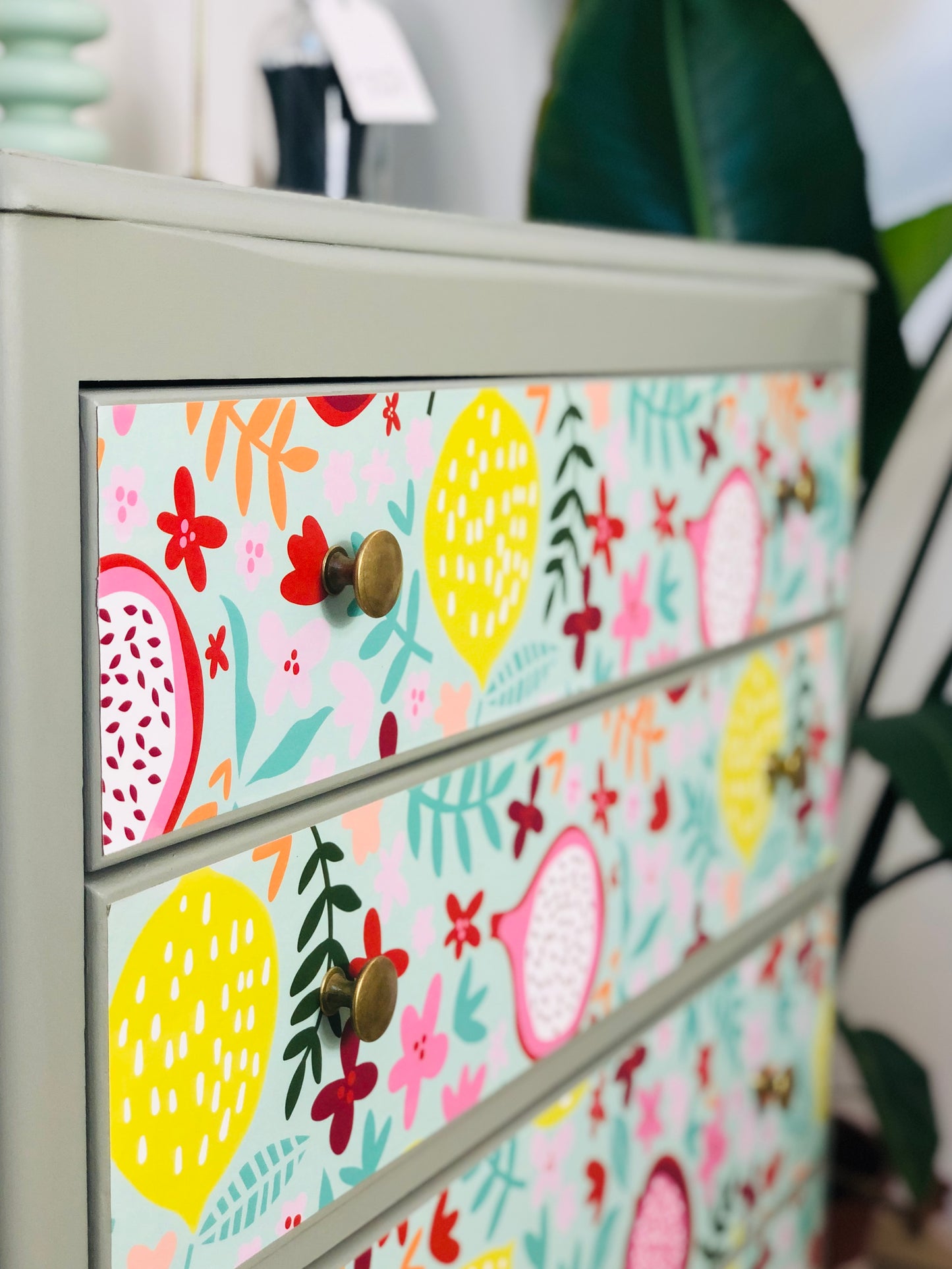 . Chest of Drawers, Painted Neutral Green, With Colourful Fruit And Floral Wallpaper Design